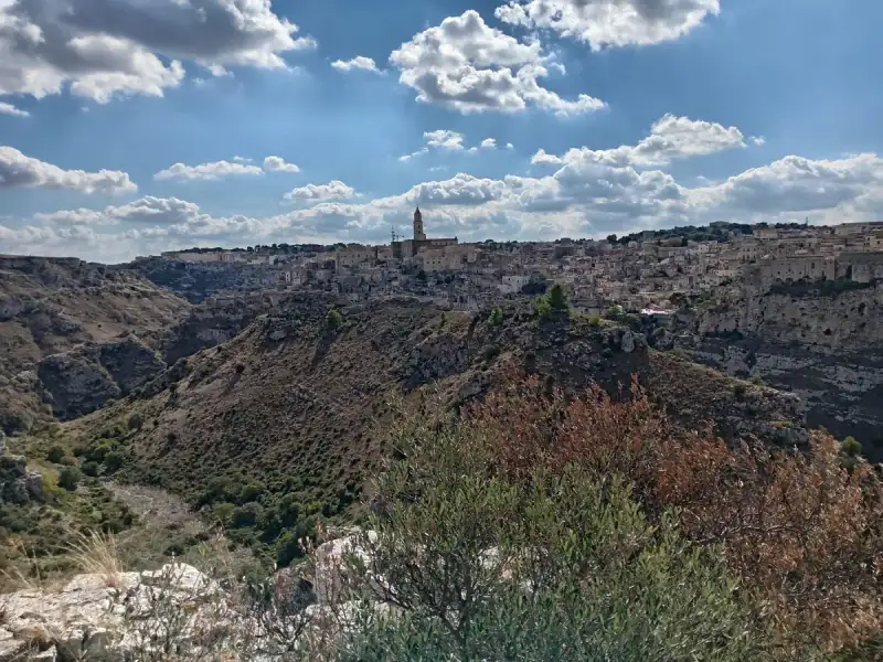 Blick von der Murgia über die Gravina-Schlucht auf die Sassi von Matera, im Hintergrund der Turm der Kathedrale.
