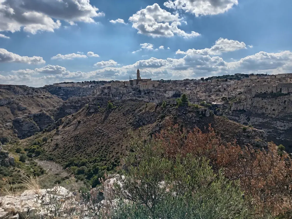 Blick von der Murgia über die Gravina-Schlucht auf die Sassi von Matera, im Hintergrund der Turm der Kathedrale.