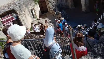 Besucher auf einer Treppe vor einem historischen Eingang in Matera